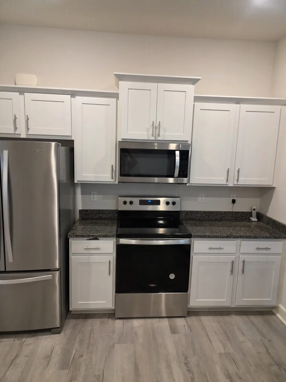 Residential kitchen with white cabinetry and stainless steel appliances